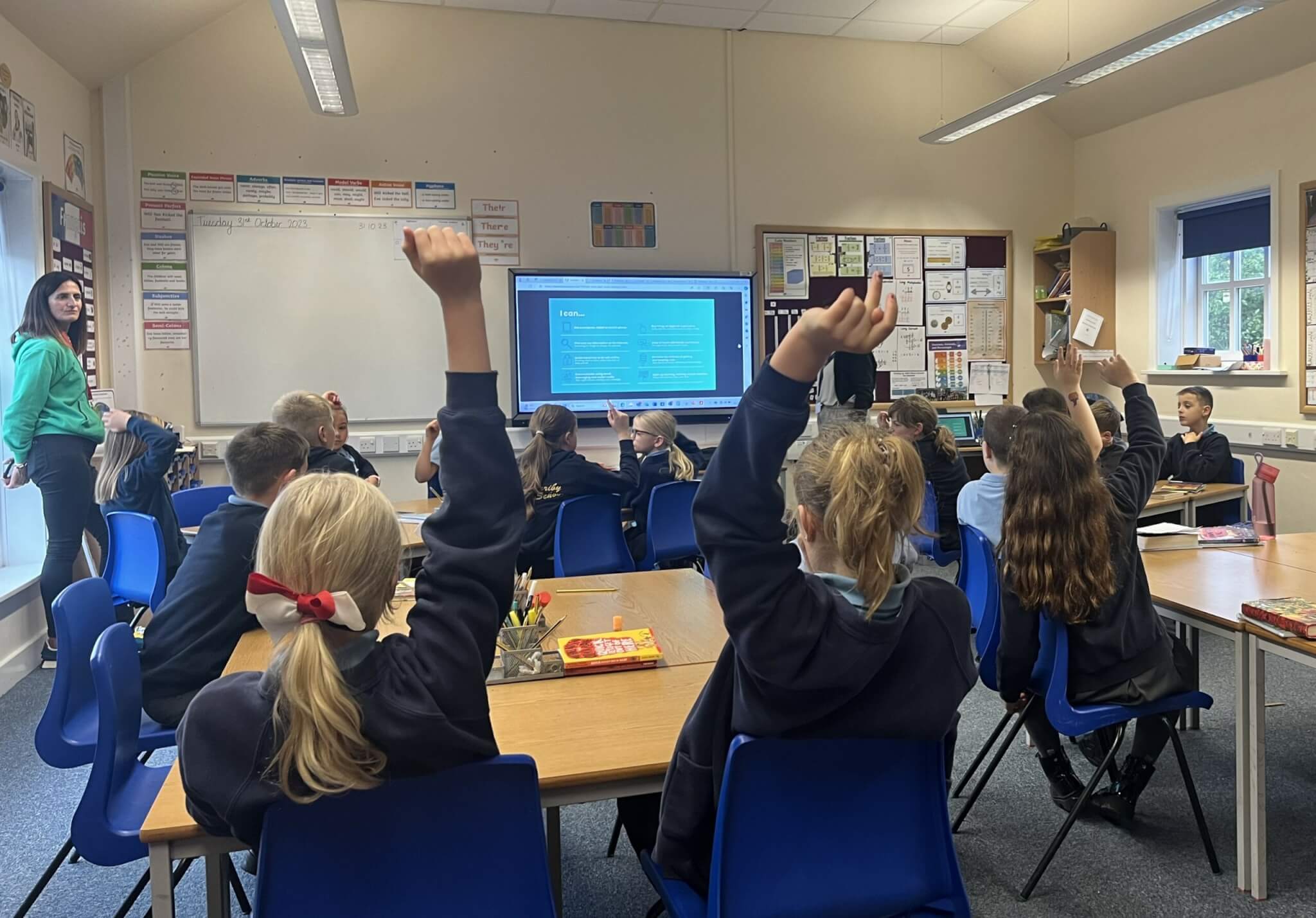 Engaging Education Digital Skills Classroom with hands Raised